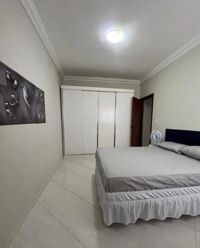 a bedroom with a bed and a painting on the wall at 2 quartos com garagem coberta in Vitória da Conquista