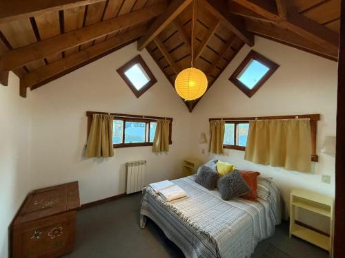 a bedroom with a bed in a room with windows at Inlandsis Aparts in El Chalten