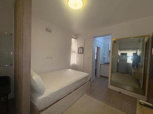 a bedroom with a white bed and a mirror at Exquisite 1-bed studio apartment in Ikoyi in Lagos