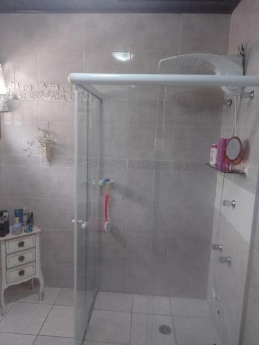 a shower with a glass door in a bathroom at Aconchego da Wal in Campos do Jordão