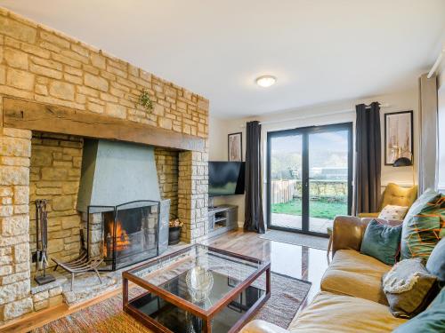 a living room with a fireplace and a couch at Cromwell House - Uk42450 in Winforton