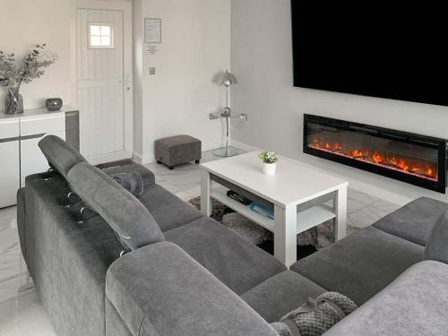 a living room with a couch and a fireplace at Red Kite Cottage-Ukc6982 in Consett