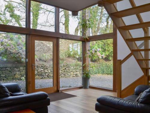 a living room with a large glass door at Polmear Barn in Camelford