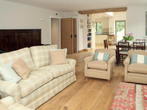 a living room with two couches and two chairs at Kites Gate Cottage in Kingham