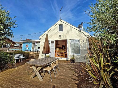 a patio with a wooden table and a house at Dinky Daze - Ukc7071 in Brundall