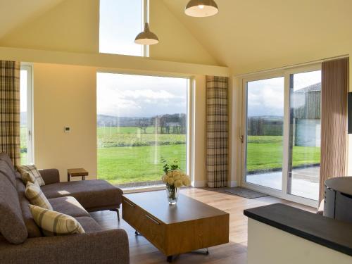a living room with a couch and a table at Falcon Cottage in Linlithgow