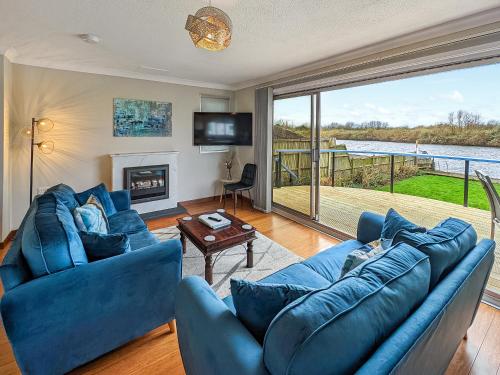 a living room with a blue couch and a fireplace at River View-Ukc6112 in Brundall