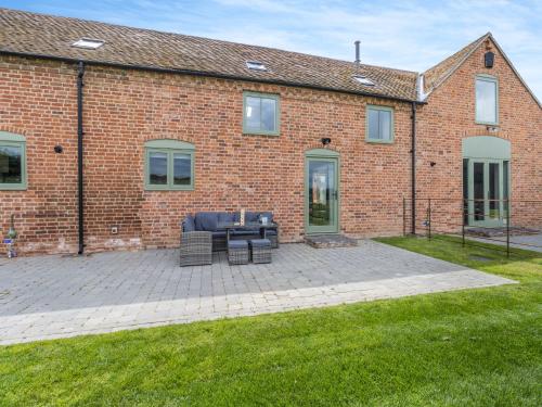 a brick building with a couch in front of it at The Dairy - Uk44130 in Baystonhill