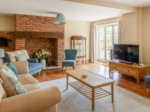 a living room with a couch and a tv at Lower Barrowfield Farm in Beaminster