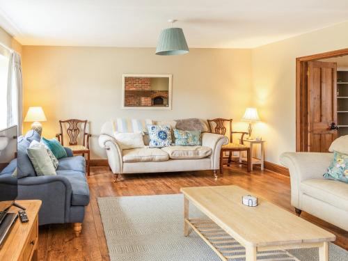 a living room with two couches and a table at Lower Barrowfield Farm in Beaminster