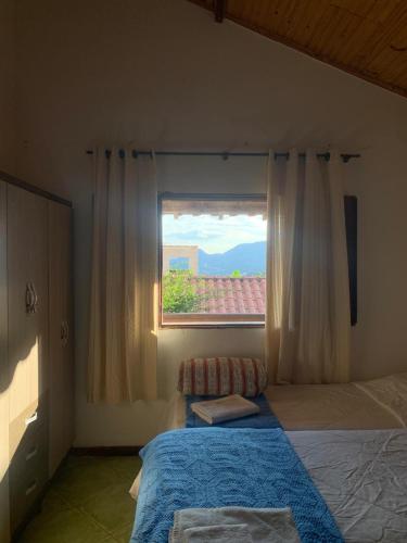 a bedroom with a bed and a window at Casa vicentina in Tiradentes