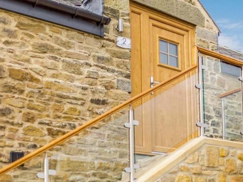 a wooden door on the side of a stone building at Swallow Cottage-Ukc6983 in Castleside