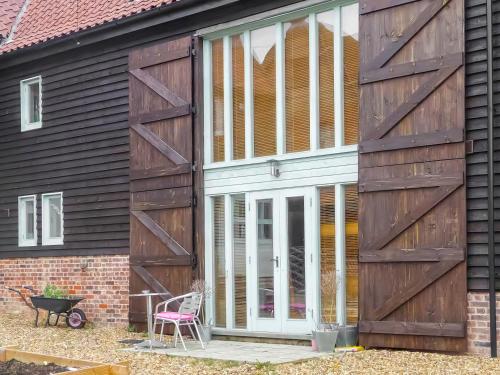 a sliding barn door on the side of a house at Holly Barn in Ashwellthorpe