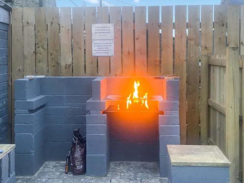 a fire pit made out of bricks in front of a fence at Barn Owl Cottage- Ukc6985 in Castleside