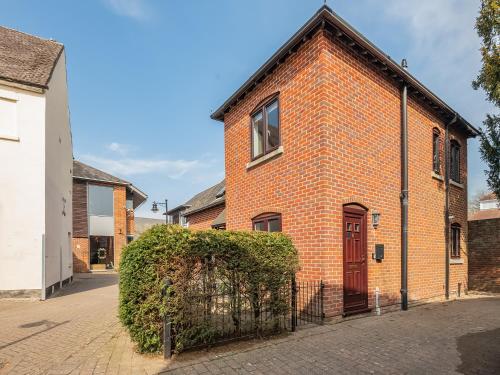 a brick building with a red door on a street at Star Cottage in Ringwood