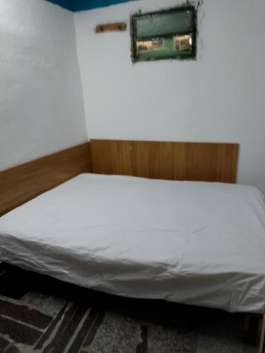 a bed in a room with a white bedsheet at El buen descanso in Trelew