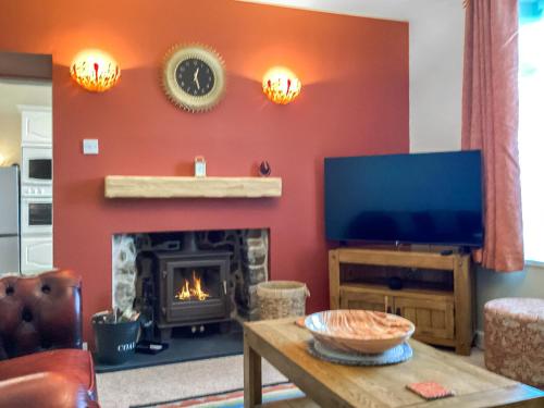 a living room with a fireplace and a flat screen tv at Seaspray in Buckie