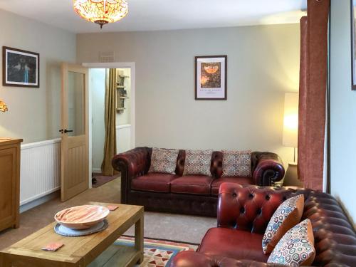 a living room with a leather couch and a table at Seaspray in Buckie