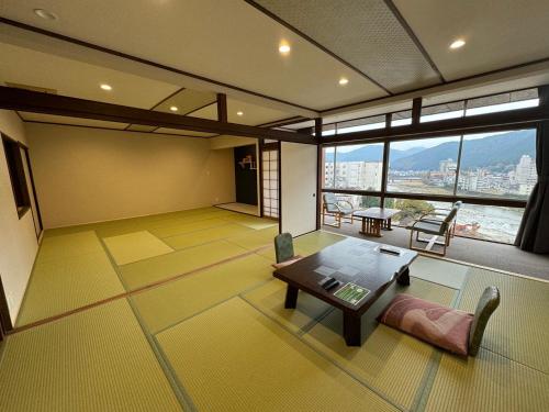a living room with a table and a large window at Bosenkan in Gero