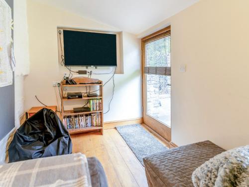 a living room with a flat screen tv on the wall at Wern Farm Barn in Cwm-du