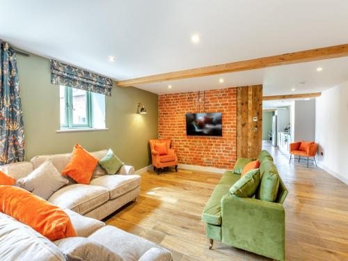 a living room with two couches and a brick wall at The Stables - Uk44139 in Baystonhill