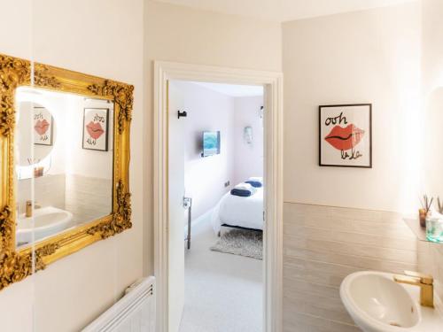 a bathroom with a mirror and a sink and a tub at The Wharf in Warwick