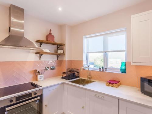 a kitchen with white cabinets and a window at The Wharf in Warwick
