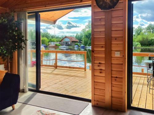 a door leading to a deck with a view of the water at Nature's Nook in Brundall