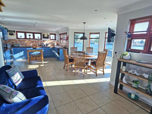 a living room with a table and chairs and a kitchen at Flag House - Ukc7074 in Brundall