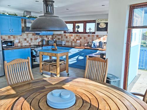 a kitchen with a table with plates on it at Flag House - Ukc7074 in Brundall