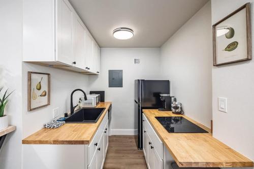 a kitchen with white cabinets and a black refrigerator at King Bed Studio-Downtown Getaway in Anchorage