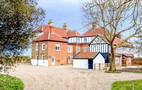 a large red brick building with a white garage at The Dower House in Thorpeness
