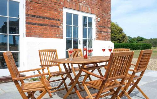 a wooden table with four chairs and wine glasses at The Dower House in Thorpeness