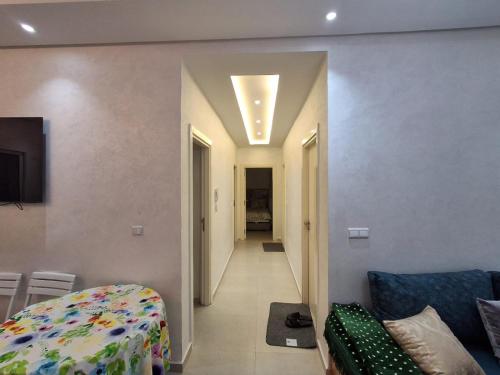 a living room with a bed and a hallway at Appartement Residence Tafoult IMIOUADDAR in Agadir nʼ Aït Sa
