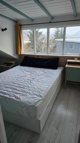 a large bed in a room with a window at Cozy Fjord Loft in Reyðarfjörður