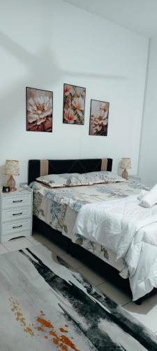 a bedroom with a bed and two pictures on the wall at FS Homestay Cherating in Kuantan