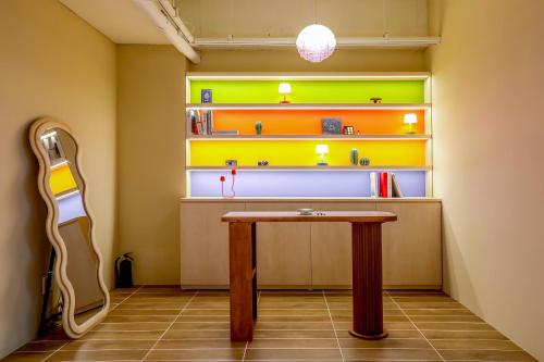 a room with a table and a guitar next to a shelf at Hotelarrive Seoulful in Seoul