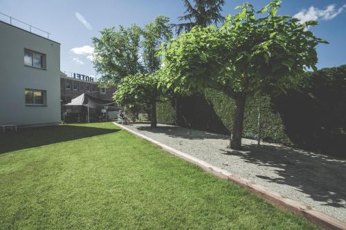 a row of trees in a yard next to a building at Hôtel Karène in Saint-Paul-lès-Romans