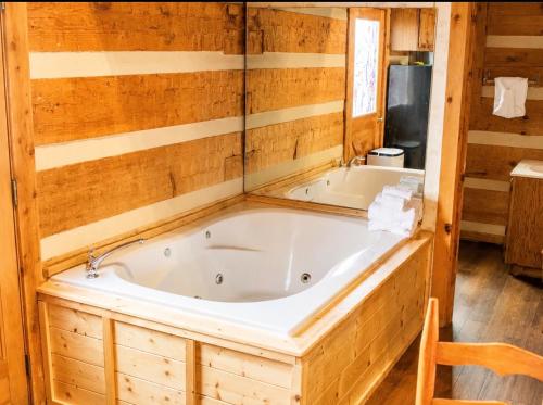 a jacuzzi tub in a log cabin bathroom at Bearfoot Bungalow- Tiny Cabin Getaway in Sevierville