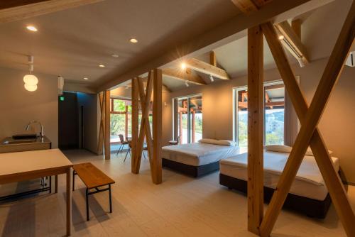 a bedroom with two beds and a table and a desk at Asahi Shizenkan in Asahi-machi