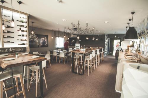 a restaurant with tables and chairs and a bar at Hôtel Karène in Saint-Paul-lès-Romans