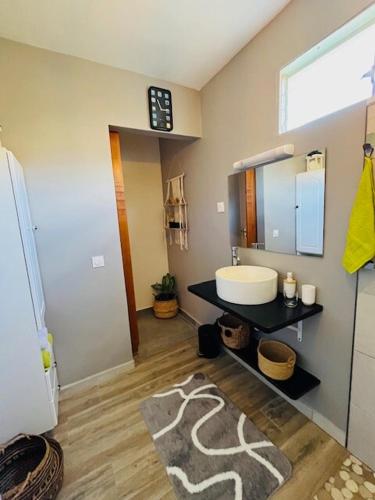 a bathroom with a sink and a mirror at Chalet du Soleil in Pointe-Noire
