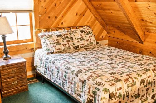 a bedroom with a bed and a lamp on a night stand at Bearfoot Bungalow- Tiny Cabin Getaway in Sevierville