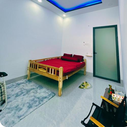 a bedroom with a bed with a red blanket at La Maison de My Tho in Mỹ Tho
