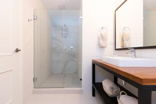 a white bathroom with a shower and a sink at The Friendly Condo by AcoModo Punta Caelo in El Nance