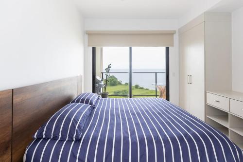 a bedroom with a bed with blue and white stripes at The Friendly Condo by AcoModo Punta Caelo in El Nance