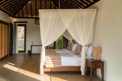 a bedroom with a bed with a canopy at Menjaga Bay in Labuan Bajo