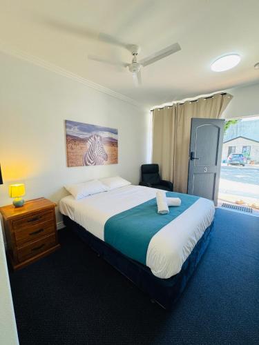 a bedroom with a large bed and a window at Pacific Motel Taree in Taree