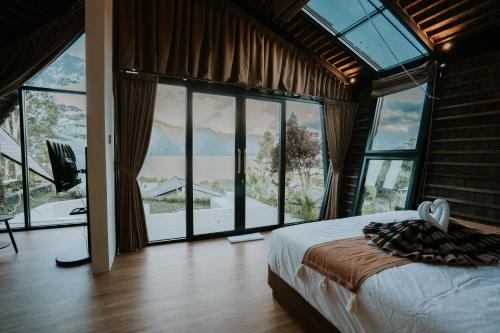 a bedroom with a bed and large glass windows at Skylake Villa in Kubupenlokan
