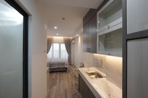 a bathroom with a sink and a bed in a room at Skyview Apartment by Grand Sky Hotel in Sunggal